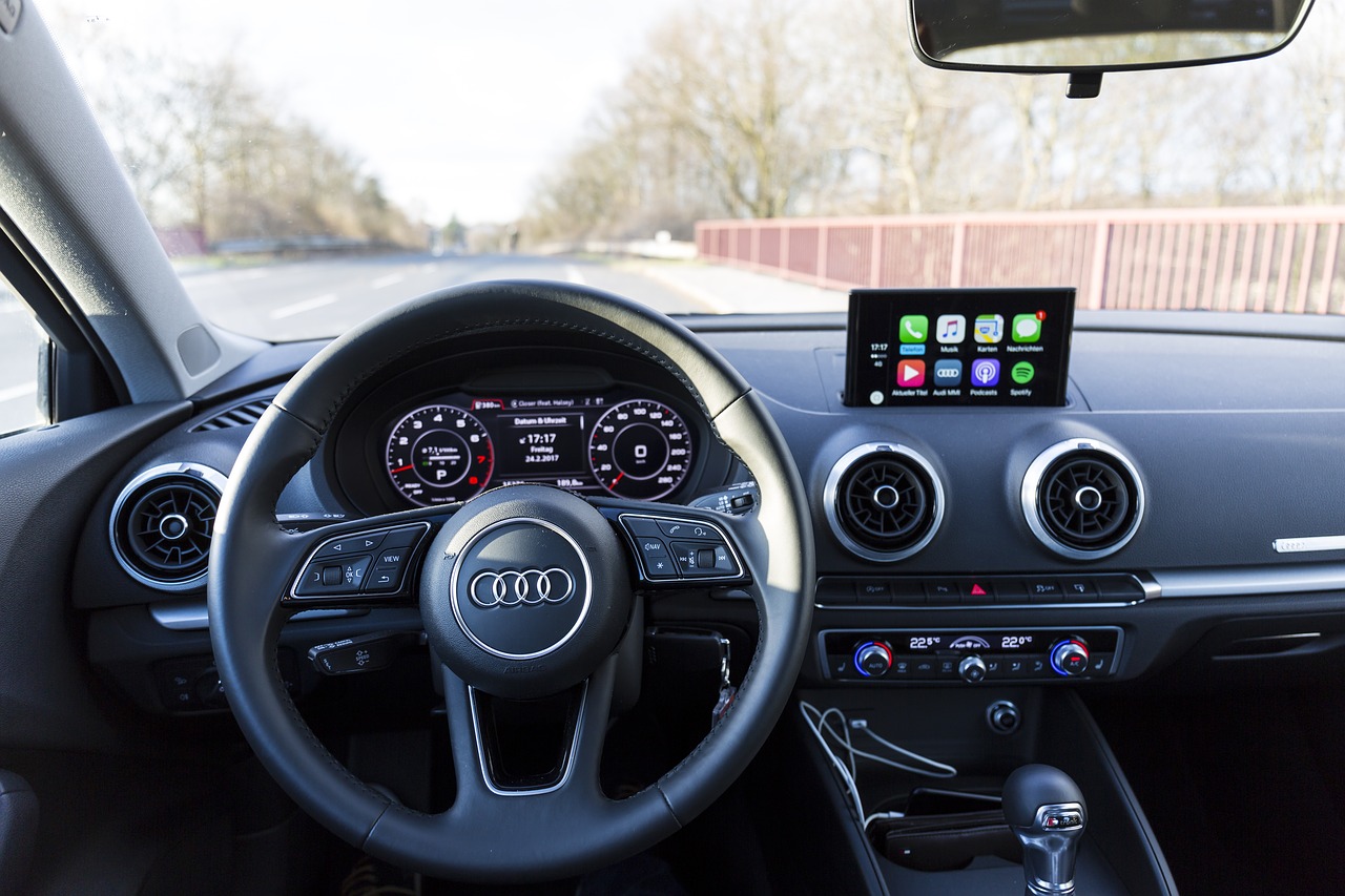 A car dashboard with the steering wheel and infotainment system.